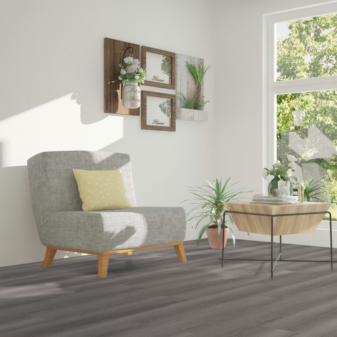 Sonnenreiches Wohnzimmer mit einem grauen Sessel und einem Holztisch mit Klick Vinyl Eiche Brocken Boden 