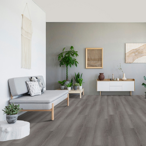 Helles Wohnzimmer mit einem grauen Sofa und Holzmöbeln wurde mit Klick Vinyl Eiche Brocken verlegt 