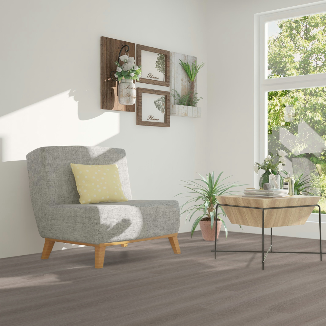 Sonnengeströmter Eckbereich mit einem grauen Sessel und Klick Vinyl Eiche Comer See Boden 